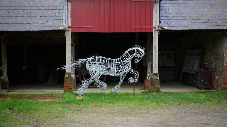 A metal sculpture of a Gypsy Cob Horse called Prissy, the sculpture is standing outside a barn at Saddlescombe Farm